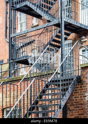 Außentreppe aus Metall Feuerleiter auf alten Backsteingebäude, Twickenham, Middlesex, größere London, UK Stockfoto