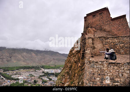 (140819)--GYANGZE, 19. August 2014 (Xinhua)--ein Tourist (R) sieht von der Zongshan Burg in der Kernstadt von Gyangze County in Shigaze, Südwest-China Tibet autonome Region, 14. August 2014. Gyangze der Zongshan Burg, ein Berggipfel, gehörte zu den wichtigsten Schlachtfelder während der britischen Invasion Tibets von Dezember 1903 bis September 1904. Etwa 5.000 verteidigenden Soldaten stationiert in der Burg für drei Tage gegen die britischen Truppen gekämpft aber es versäumt, den Angriff zu widerstehen, die am 6. Juli 1906 begann. Nicht bereit zu kapitulieren, wählten die übrigen Soldaten der Z springen Stockfoto