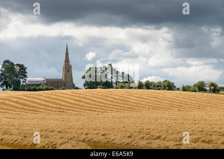 Wenig Staughton, Bedfordshire, UK. 19. August 2014. Dunkle Wolken über der Kirche und neu geernteten Weizenfelder auf wenig Staughton im Norden Bedfordshire. Tagestemperaturen in weiten Teilen des Vereinigten Königreichs nicht 20 Grad C zum ersten Mal seit Anfang Juni erreicht. Sonnenschein und Duschen und eine spürbare Kälte in der Luft gab einem unverwechselbaren herbstliche Ambiente zum Wetter. Bildnachweis: Julian Eales/Alamy Live-Nachrichten Stockfoto