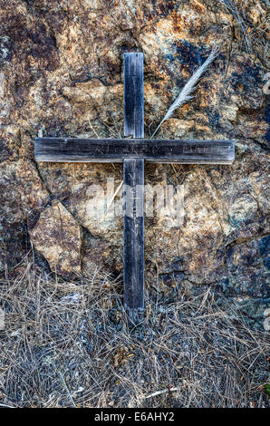 Hölzerne Kreuz gesichert durch Felsen am Straßenrand in Big Sur, Kalifornien Stockfoto