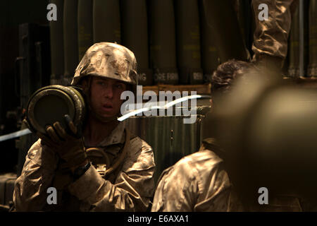 U.S. Marine Corps Lance Cpl. Christopher Hess, ein Feld-Artillerie Feuer Controlman mit Charlie Batterie, 1. Bataillon, 12. Marine Regiment, entlädt M795 Projektile Artillerie Runden von einem LKW auf dem Truppenübungsplatz Pohakuloa in Hawaii 24. Juli 2014, dur Stockfoto