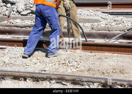 Zwei Arbeiter mit Presslufthammer Bohren Ausrüstung brechen von Beton auf der Baustelle Stockfoto