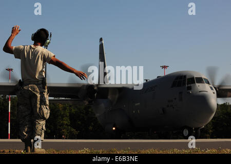 US Air Force Senior Airman Christopher Guerrero, mit der 86. Aircraft Maintenance Squadron, Marschälle eine C-130J Super Hercules-Flugzeuge 7. August 2014, Powidz Luftwaffenstützpunkt in Polen. Flieger zugewiesen 86th Airlift Wing auf der Ramstein Air Base, Deutschland, tra Stockfoto