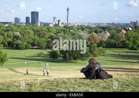 Person sitzt in Primrose Hill an einem sonnigen Tag, London, England Stockfoto