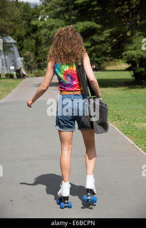 Teenager auf Rollschuhen nicht allzu zuversichtlich skaten entlang eines Pfades auf acht Rädern suchen Stockfoto