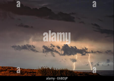 Blitze über Meer am Nachthimmel Stockfoto