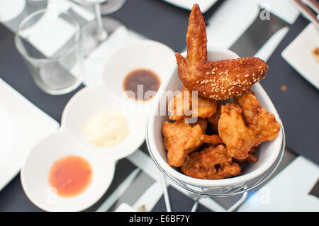 Hähnchenflügel mit drei Saucen Stockfoto