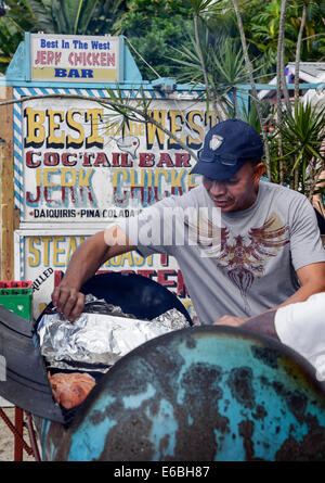 Jamaikanische Mann bereitet Ruckhuhn in eine Öl-Fass-Grill, Negril, Jamaika Stockfoto