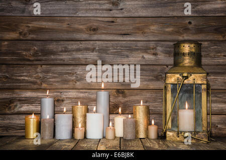 Aus Holz Vintage-Hintergrund mit vielen brennenden Kerzen und eine alte rustikale Laterne. Stockfoto