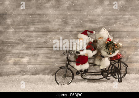 Zwei Santa Claus in Eile für den Kauf von Weihnachtsgeschenken auf hölzernen Hintergrund im Vintage-Stil eingerichtet. Stockfoto