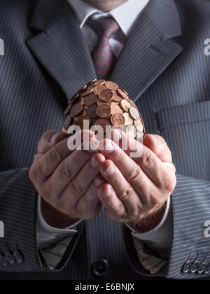 Geschäftsmann in Anzug mit einem Cent Ei in den Händen Stockfoto
