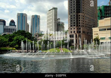 KUALA LUMPUR, MALAYSIA: Brunnen spielen im KLCC Park hinter die Suria KLCC shopping Komplex und Zweibettzimmer Petronas Towers Stockfoto