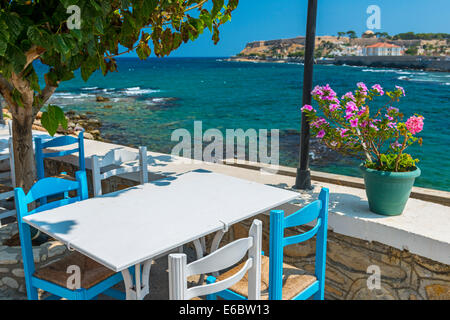 Tisch und Stühle In einer typischen Taverne am Meer in Rethymnon, Kreta, Griechenland Stockfoto