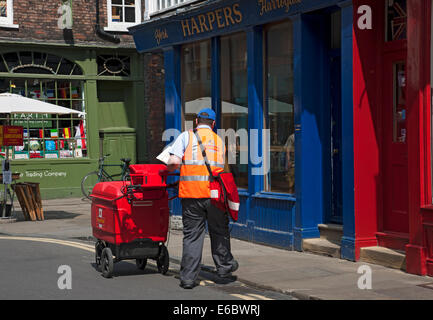 Postbote Pushing Trolley Postbriefpost in der Innenstadt von York North Yorkshire England Großbritannien GB Großbritannien Stockfoto