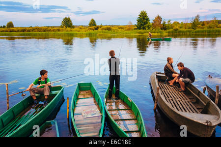 MINSK, BELARUS - 25 Juli: Belarussischer Kinder Angeln vom alten Boote bei Sonnenuntergang an einem Sommertag am 25. Juli 2013 in Minsk, Belaru Stockfoto