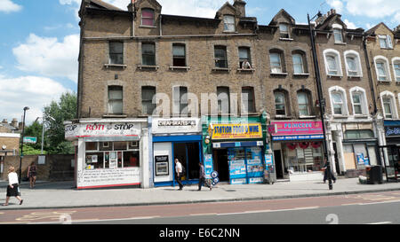 Menschen, die an Reihenwohnungen über kleine Geschäfte auf der Stoke Newington High Street Stamford Hill vorbeigehen London N16 Großbritannien KATHY DEWITT Stockfoto