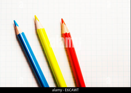 blaue rote und gelbe Bleistift auf weißem Papier Stockfoto