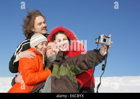 Vier Freunde, die Aufnahme eines Fotos im winter Stockfoto