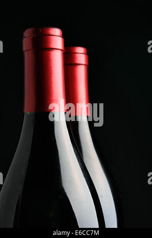 Zwei verkorkten Weinflaschen auf schwarzem Hintergrund Stockfoto
