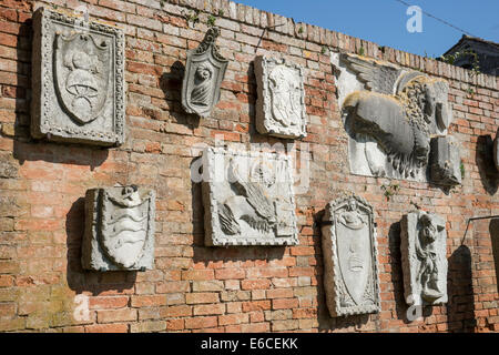 Ziegelwand hinter Torcello-Museum mit alten Relief-Skulpturen auf der Insel Torcello in der Lagune von Venedig. Stockfoto