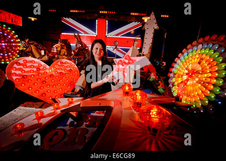 Olivia Yip umgeben von Leuchtreklamen in ihrem Showroom bei Oakley Illuminationen in Hastings. Stockfoto