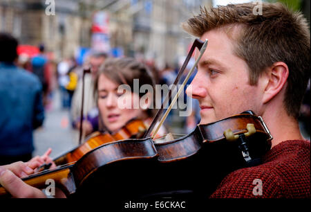 Zwei Fiddlers unterhalten während des Fringe-Festivals in der High Street, Edinburgh Stockfoto