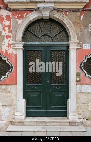 Nahaufnahme der grünen Tor in altes Haus mit läutenden Putz auf der Insel Burano in der venezianischen Lagune. Stockfoto