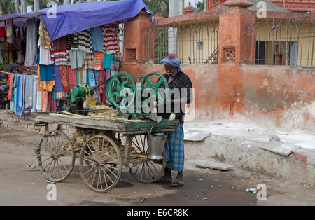 Mann mit Zuckerrohr Pressmaschine montiert auf einem Wagen. Stockfoto