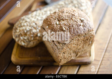 Stücke von hausgemachten Vollkorn Brot über Holztisch Stockfoto