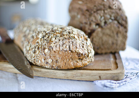 Stücke von hausgemachten Vollkorn Brot über Holztisch Stockfoto