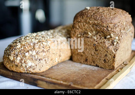 Stücke von hausgemachten Vollkorn Brot über Holztisch Stockfoto