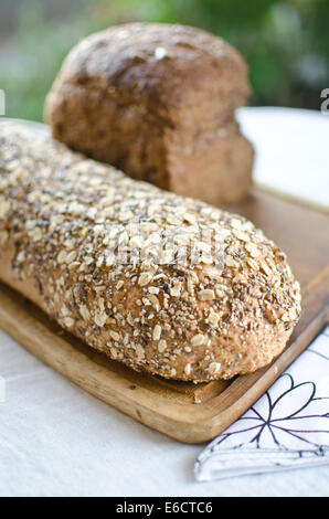 Stücke von hausgemachten Vollkorn Brot über Holztisch Stockfoto