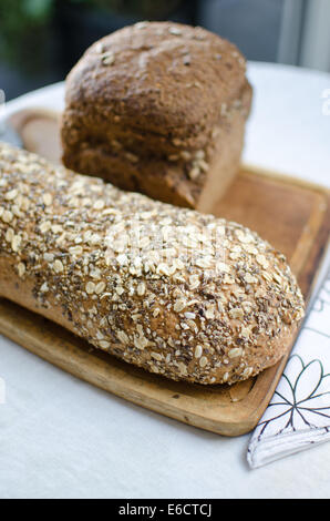 Stücke von hausgemachten Vollkorn Brot über Holztisch Stockfoto