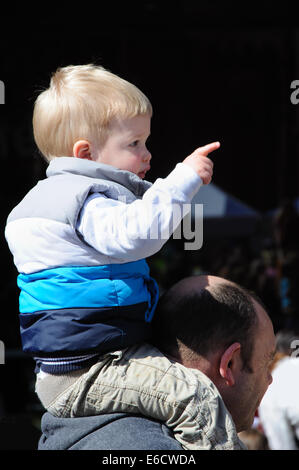 kleiner Junge sitzt auf Vaters Schultern, England, UK Stockfoto