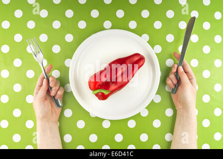 Frau essen frische rohe Paprika auf einem weißen Teller, Ansicht von oben. Stockfoto