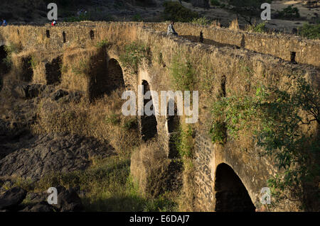 Kleiner Junge sitzt auf der alten Steinbrücke an der Blue Nile fällt (Tis Abay), in der Nähe von Bahir Dar, Äthiopien Stockfoto