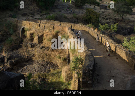 Dorfbewohner, die zu Fuß über die alte Steinbrücke bei der Blue Nile fällt (Tis Abay), in der Nähe von Bahir Dar, Äthiopien Stockfoto