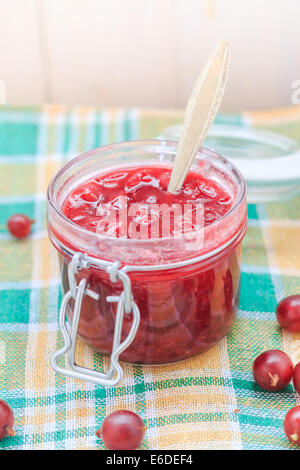 Stachelbeere Konfitüre mit einem Löffel in ein Glas Stockfoto