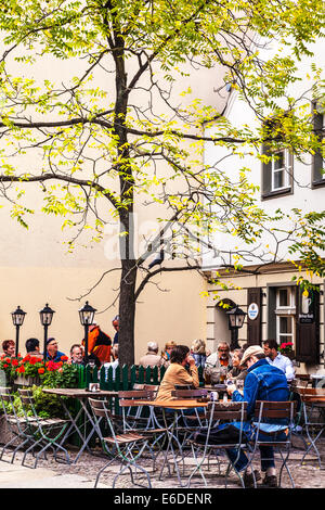 Menschen, die einen Drink in einem Straßencafé in der Nicholas Quarter von Berlin. Stockfoto