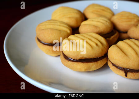 Nahaufnahme von einem Teller Kekse mit Schokolade Haselnuss Nässen verbreiten Füllung Stockfoto
