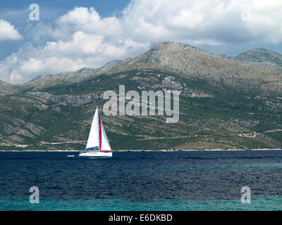 Segelboot Segel durch blaue Wasser von der Insel Lopud Urlaub in Kroatien an einem sonnigen Sommertag mit kroatischen Festland im Hintergrund Stockfoto