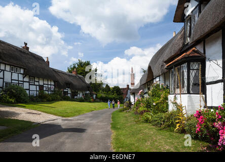 Drei Dame Wanderer zu Fuß vorbei an den Fachwerk- und strohgedeckten Hütten Boot Lane an einem Sommertag in Welford-on-Avon, Warwickshire, England Stockfoto