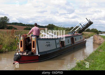 Narrowboat Unterquerung einer Aufhebung-Brücke auf dem Kanal von Oxford, Oxfordshire, Vereinigtes Königreich Stockfoto