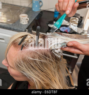 Eine Frau, die Höhepunkte stellen in ihrem Haar durch einen Friseur im Vereinigten Königreich Stockfoto