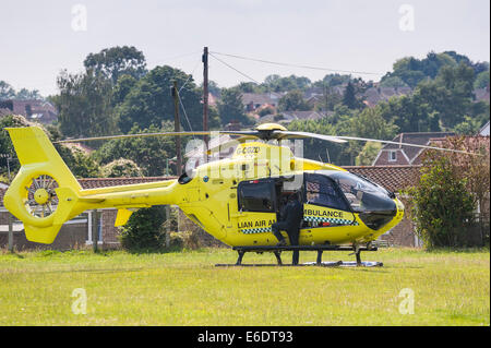 Die Air Ambulance landete auf einem Spielfeld Schule im Umgang mit einem Aufruf in Beccles, Suffolk, England, Großbritannien, Uk Stockfoto