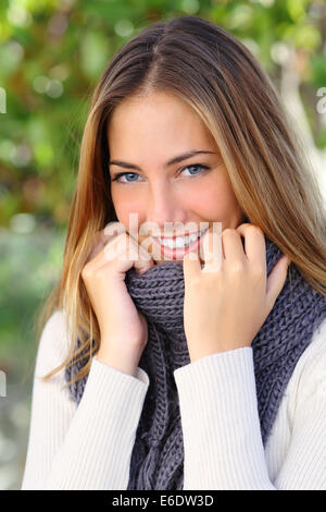 Schöne Frau mit einem weißen perfektes Lächeln und blauen Augen im Winter warm bekleidet Stockfoto