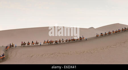 Touristen, Kamelreiten auf berühmte Shan, Dunhuang, Jiuquan, Provinz Gansu, China Stockfoto