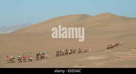 Touristen, Kamelreiten auf berühmte Shan, Dunhuang, Jiuquan, Provinz Gansu, China Stockfoto