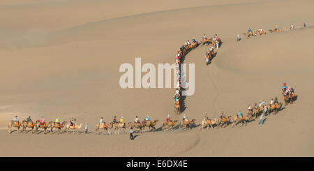 Touristen, Kamelreiten auf berühmte Shan, Dunhuang, Jiuquan, Provinz Gansu, China Stockfoto