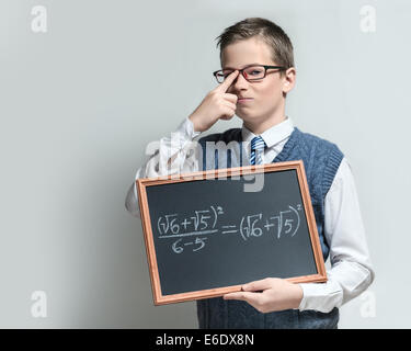 Die intelligente Schüler Teenager in einer Brille zeigt die Tafel mit der mathematischen Gleichung Stockfoto